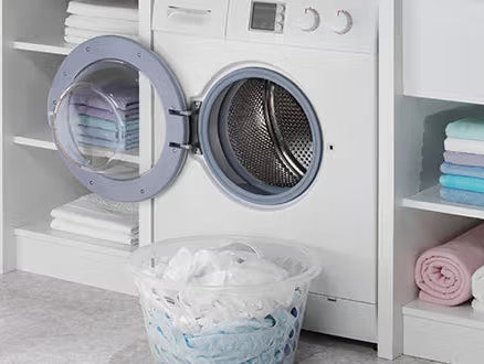 Une buanderie avec une machine à laver et du linge dans une pannière