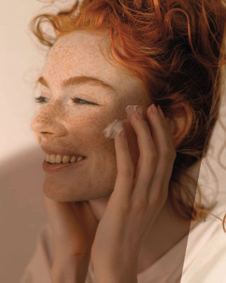 Une femme s'applique de la crème sur le visage