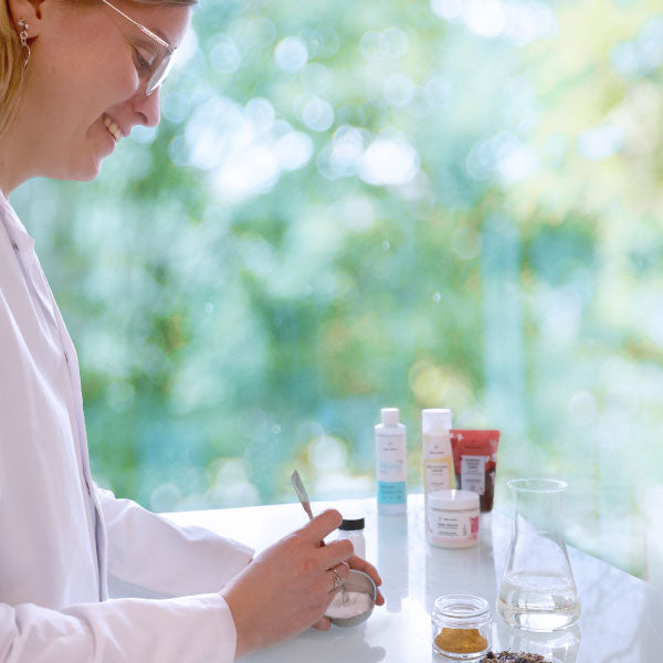 Une femme mélange des ingrédients pour la création de produits.