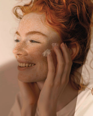 Une femme s'applique de la crème sur le visage